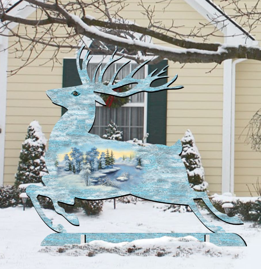 A large, stylized reindeer sculpture stands in the snow in front of a house, with a wreath hanging on the door.