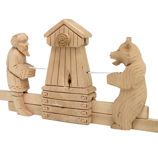 A wooden sculpture depicting a man playing a musical instrument and a bear standing next to a wooden structure.