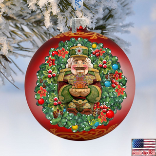 A red Christmas ornament with a nutcracker figure and a wreath of flowers, set against a snowy background.