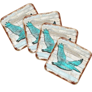 four square coasters with a blue bird design on them.