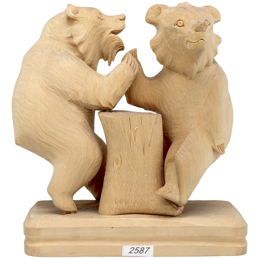A wooden sculpture depicting two bears standing on a tree stump.