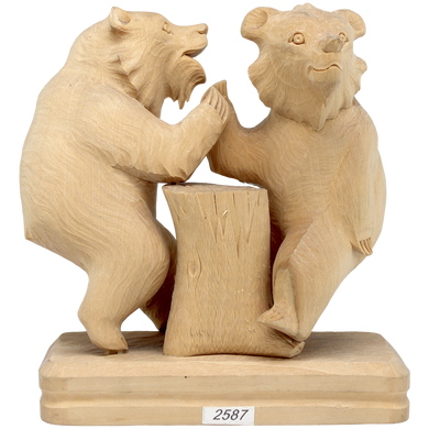 A wooden sculpture depicting two bears standing on a tree stump.
