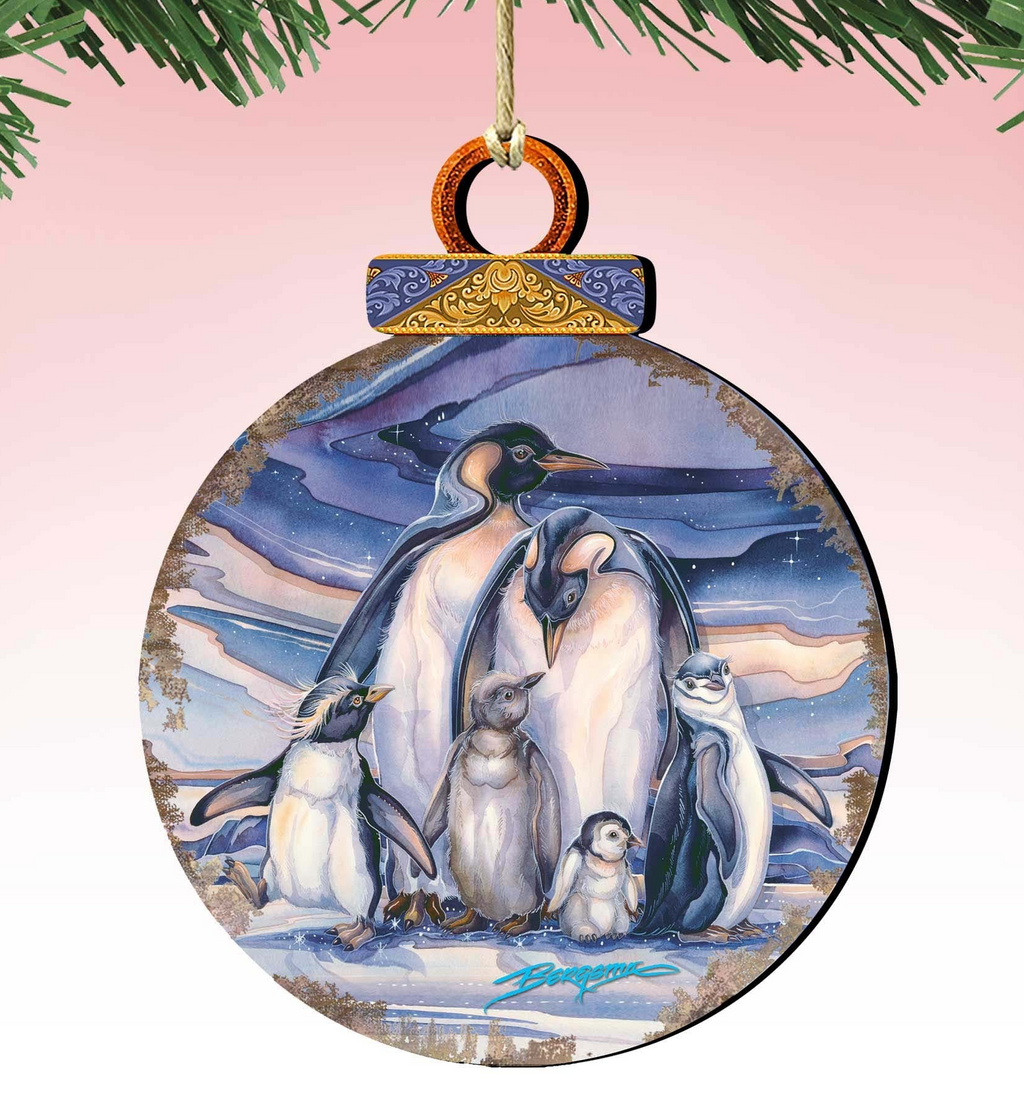 A round ornament featuring a group of penguins standing together against a snowy background.