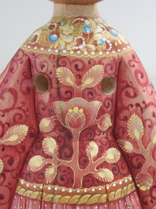 a close-up view of a beautifully decorated vase with intricate floral patterns and designs in shades of red and gold.