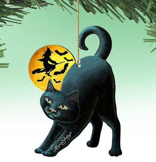 A black cat ornament with a witch on a broomstick and a full moon in the background, hanging from a string.