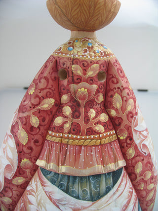 a close-up view of a decorative red and gold dress with intricate floral patterns and embellishments.