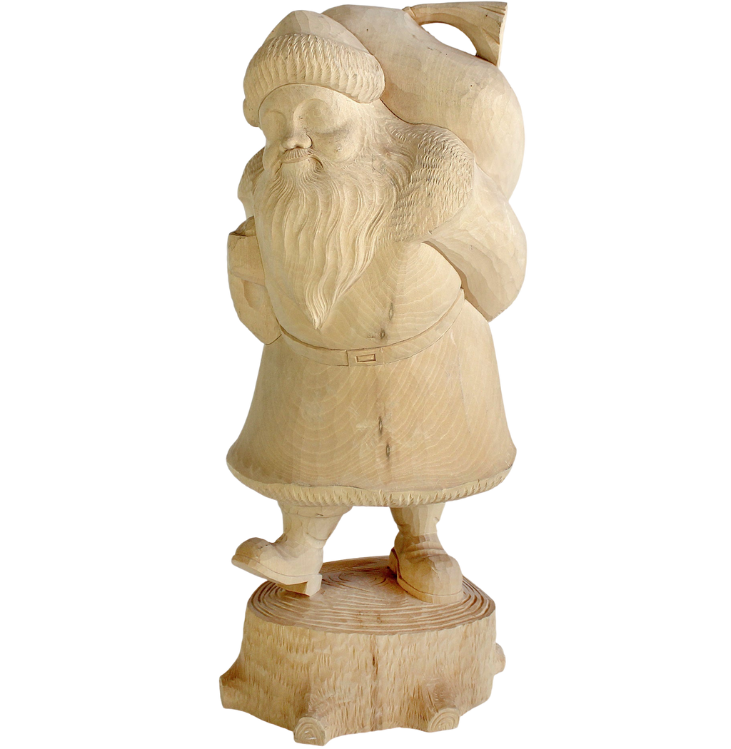 A carved wooden figure of Santa Claus carrying a sack on his back, standing on a wooden stump.