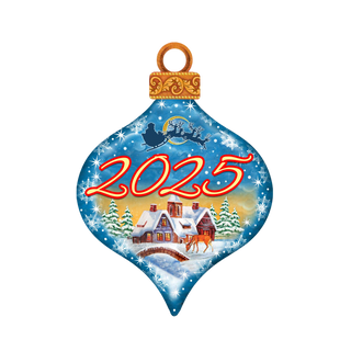 A Christmas ornament with a blue background and a snowy village scene, featuring a Santa Claus sleigh and the number