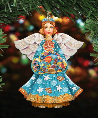 A colorful, hand-painted ornament of an angel with wings and a fish in her hand, set against a blurred background of Christmas lights.