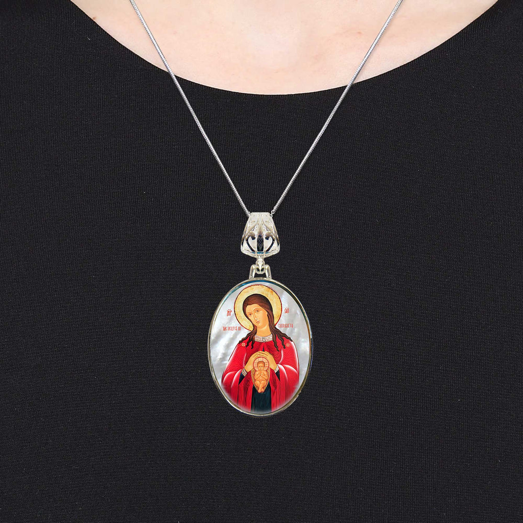 A silver necklace with a pendant featuring an image of a woman in a red robe.