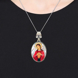 A silver necklace with a pendant featuring an image of a woman in a red robe.