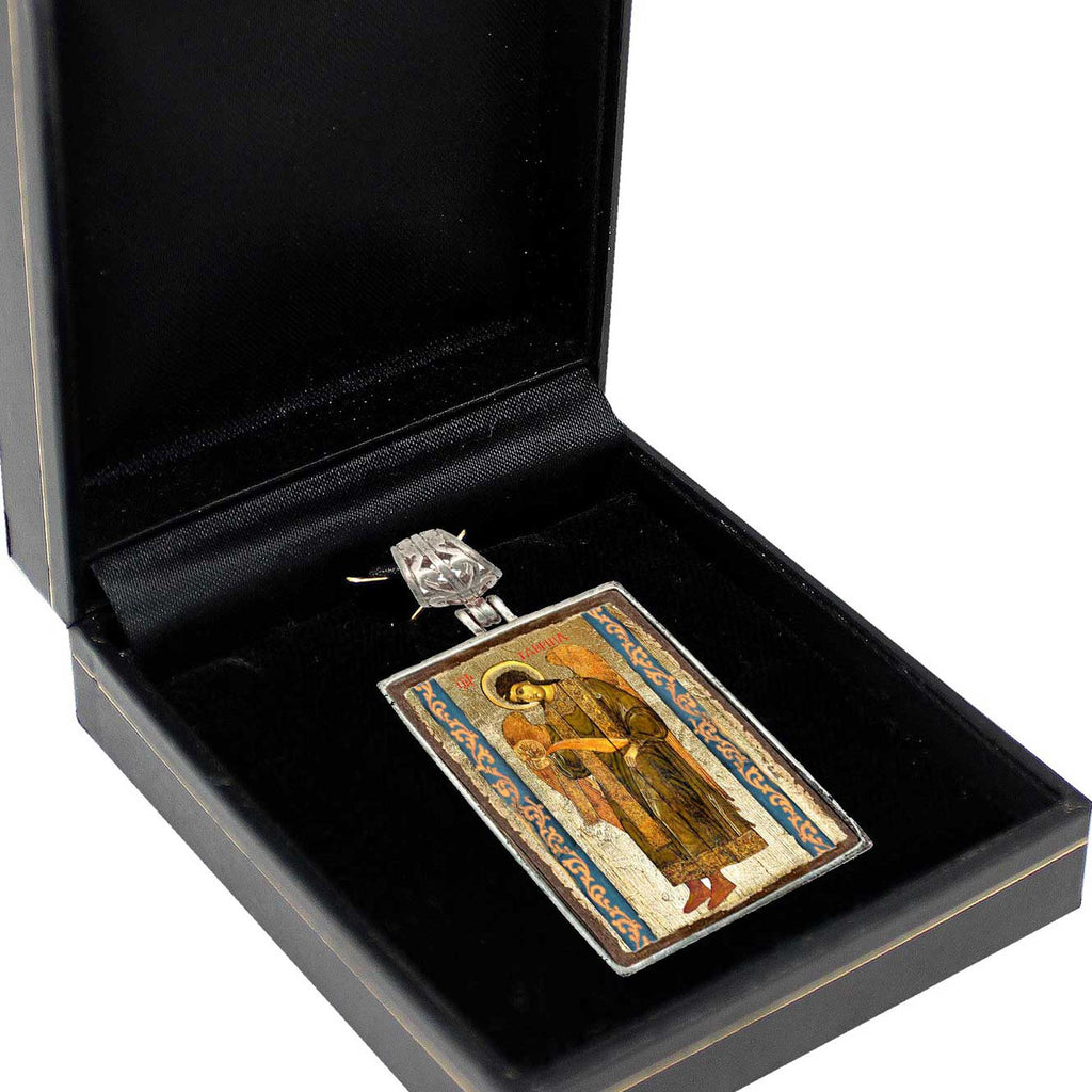 a pendant or charm displayed in a black jewelry box.