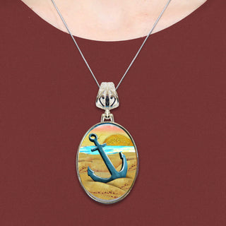 A necklace with a pendant featuring a blue anchor and a beach scene.
