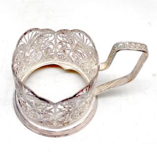 a silver teapot shaped like a heart on a white surface