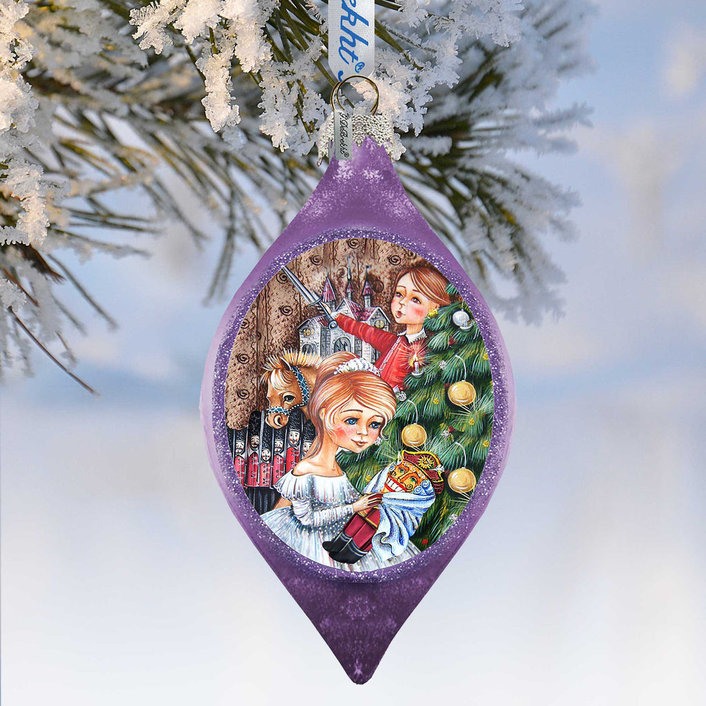 A purple ornament with a Christmas tree and two girls in the center, surrounded by snow.