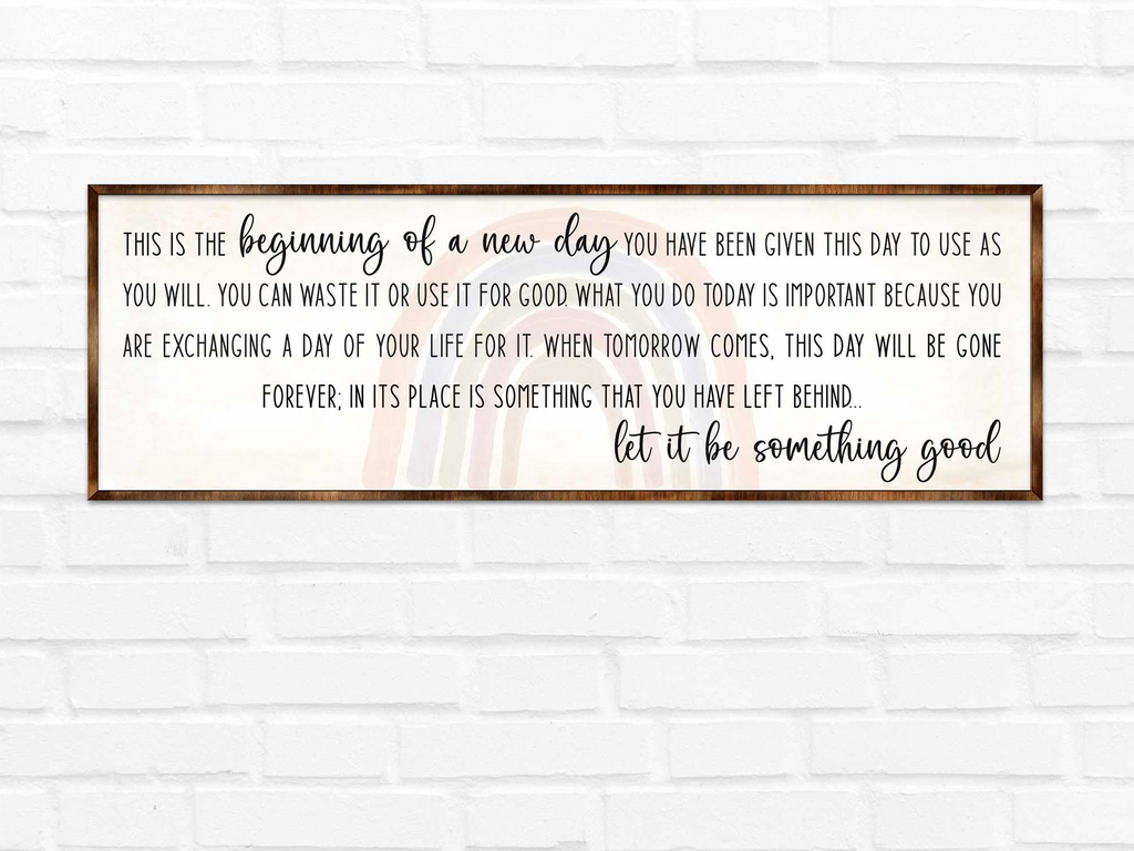 a framed inspirational quote on a white brick wall.