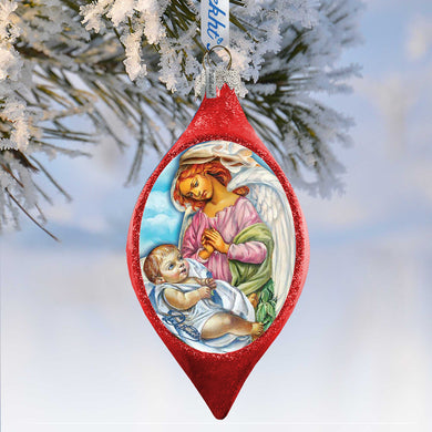 A red Christmas ornament with a painting of a baby and an angel, hanging on a tree branch covered in snow.