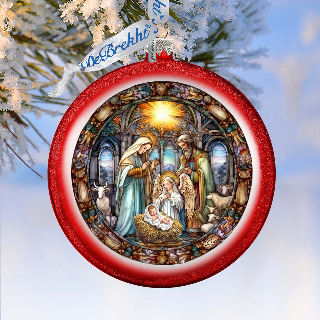 A red ornament with a detailed illustration of the nativity scene, featuring the baby Jesus, Mary, and Joseph in a church setting.