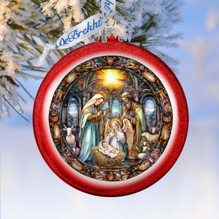 A red ornament with a detailed illustration of the nativity scene, featuring the baby Jesus, Mary, and Joseph in a church setting.