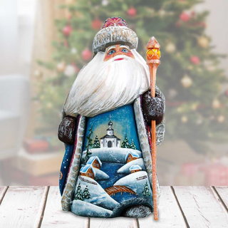 A wooden Santa Claus figurine holding a lantern and standing in front of a Christmas tree.