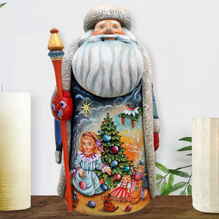 A colorful, hand-painted Santa Claus figurine with a white beard and hat, holding a red staff and surrounded by Christmas decorations and figures.