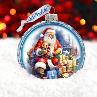 a glass ornament with a santa clause holding a teddy bear