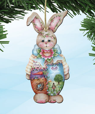 A wooden ornament in the shape of a bunny, decorated with various elements such as flowers, leaves, and a heart.