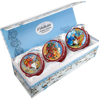 A set of three decorative Christmas ornaments in a box, each featuring a different scene from the nativity story.