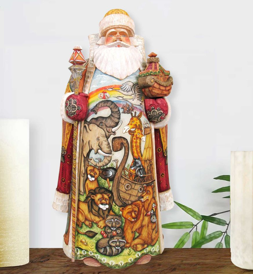 A colorful and detailed wooden statue of Santa Claus, adorned with various animals and scenes, is displayed on a wooden surface.