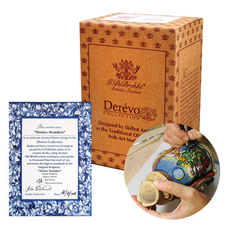 a Derevo Collection box, a blue and white certificate, and a person's hands working on a wooden object, likely a figurine or sculpture.