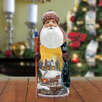 A wooden Santa Claus figurine holding a sleigh and standing in front of a Christmas tree.