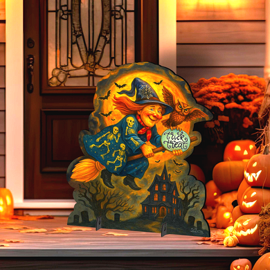 A Halloween-themed cutout of a witch riding a broomstick, holding a sign that says