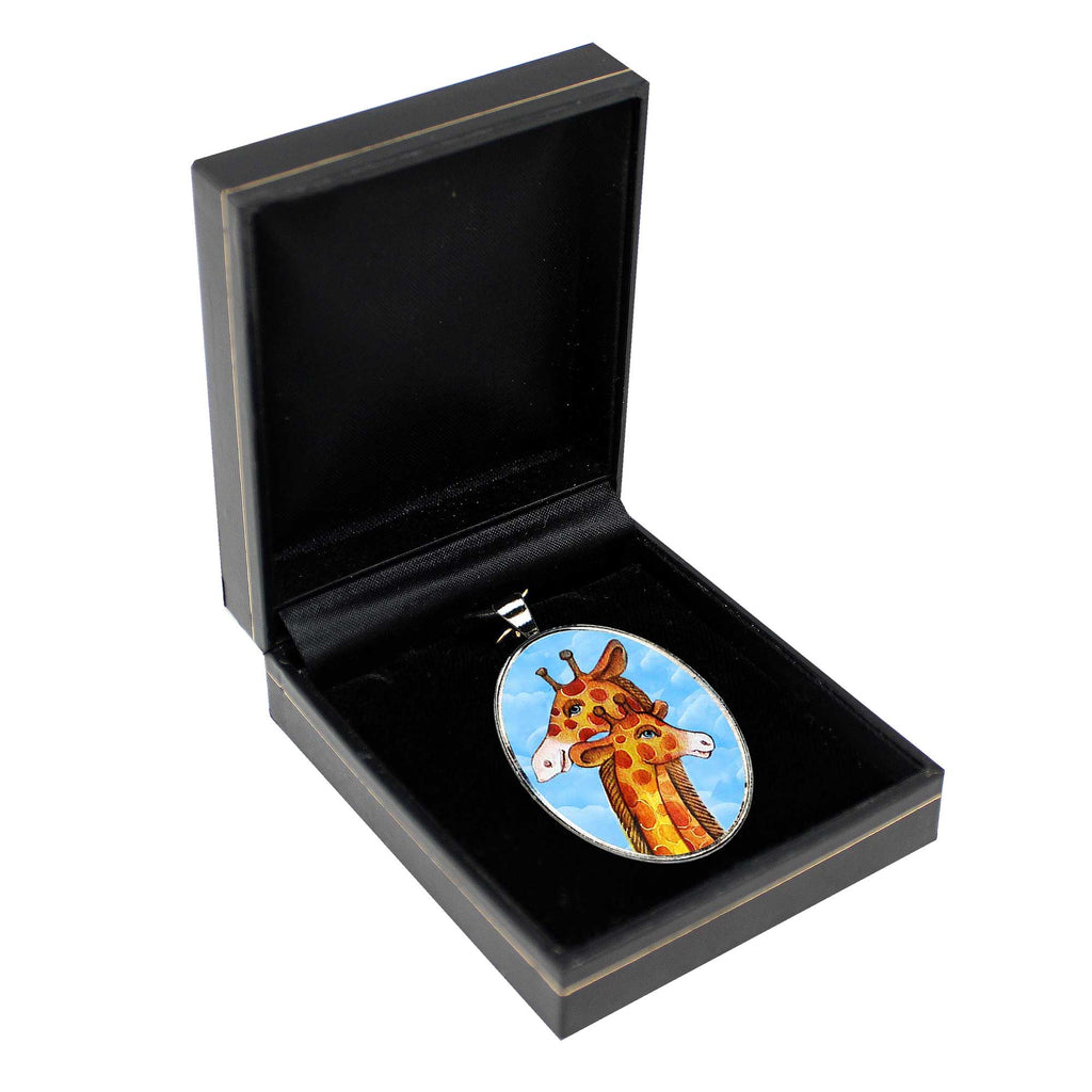 A pendant in the shape of a giraffe is displayed in a black jewelry box.