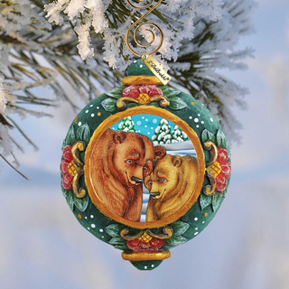 A decorative Christmas ornament featuring two bears, one brown and one tan, with a snowy background and a wreath-like design.