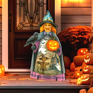 A Halloween-themed cardboard cutout of a witch holding a carved pumpkin and a bird stands on a porch surrounded by carved pumpkins and a gourd.