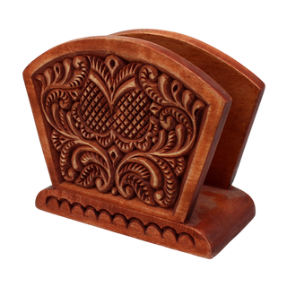 A wooden napkin holder with an intricate carved design on the back.