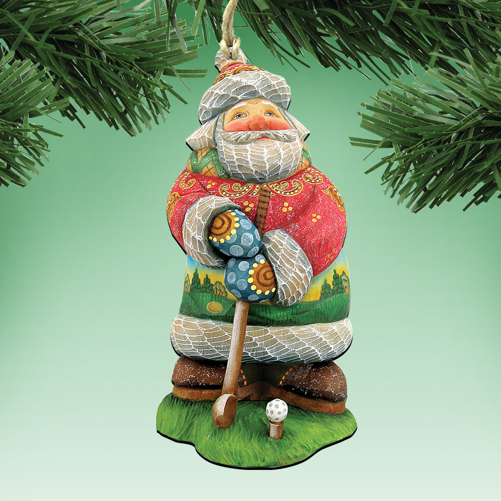 A colorful ornament of Santa Claus holding a golf club, hanging from a tree branch.