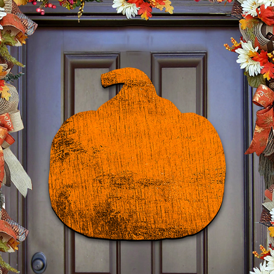 a large orange pumpkin-shaped sign hanging on a door.