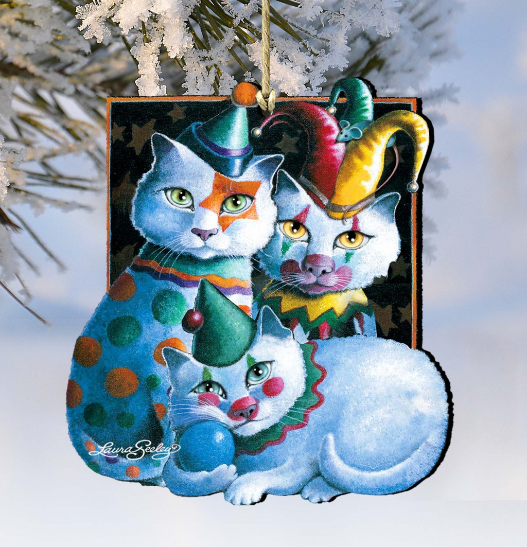 A whimsical ornament featuring three cats dressed in colorful clown hats and costumes, with one cat sitting on top of another.