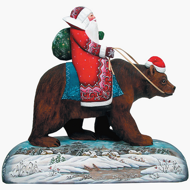 A statue of Santa Claus riding a bear, with a snowy landscape in the background.