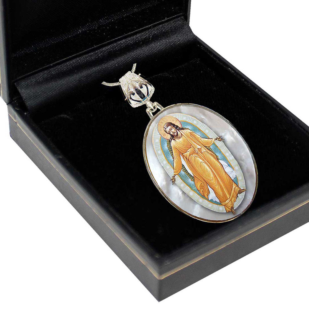 A pendant in a black box, featuring a religious icon of Jesus Christ.