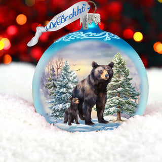 a christmas ornament with a bear and a dog in the snow