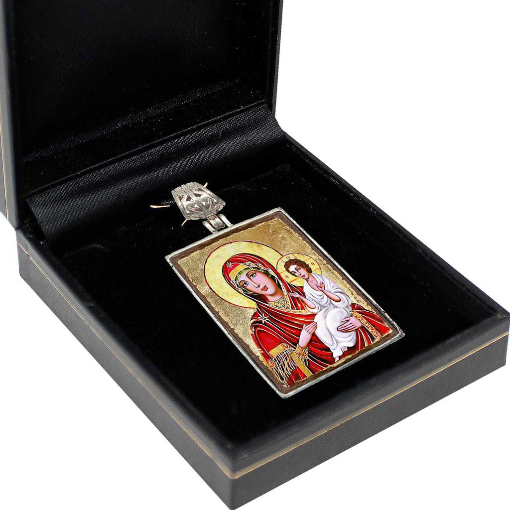 a pendant with a religious icon, such as a depiction of the Virgin Mary holding the baby Jesus, displayed in a black box.