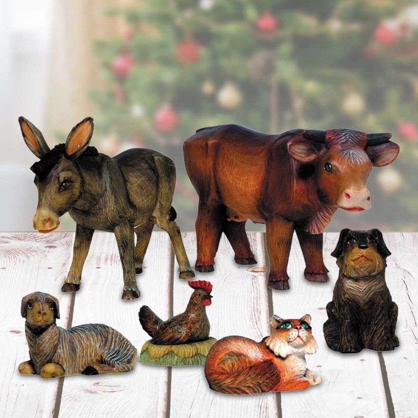 a collection of six wooden figurines depicting various animals, including a donkey, cow, chicken, dog, cat, and rooster, arranged on a wooden surface.