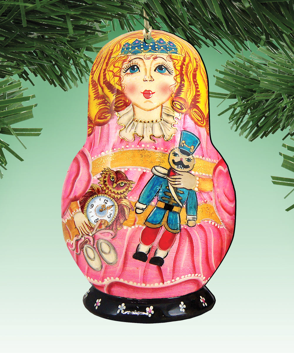 A colorful ornament featuring a painted doll with a pink dress, a nutcracker, and a clock, hanging on a tree branch.