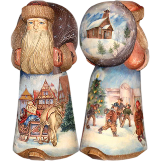 two wooden figurines depicting scenes from a winter holiday. One figurine shows a person riding a sleigh pulled by a reindeer, while the other depicts a group of people walking through a snowy landscape with a church in the background.