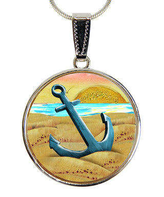 A round pendant necklace with a blue anchor and a sunset landscape in the background.
