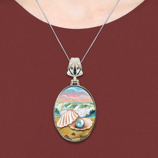 A necklace with a pendant featuring a painting of a shell with a pearl inside.