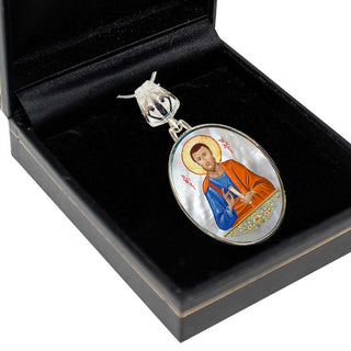 A pendant in a black box, featuring an image of a religious figure.