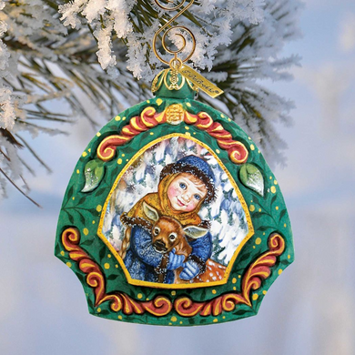 A colorful ornament featuring a young girl hugging a deer, set against a snowy background.